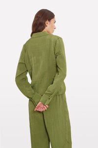 Green, textured jacket with a collar, long sleeves, and buttoned cuffs. The back shows a relaxed fit and subtle wrinkled detail.