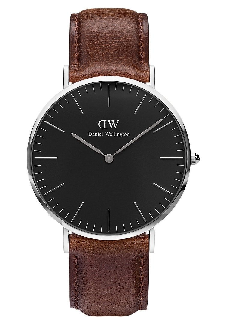 Cadran rond noir de montre Daniel Wellington avec des marqueurs d'heure et des aiguilles argentés, associé à un bracelet en cuir marron. Heure : 10h09.
