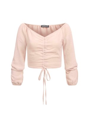 Blouse courte rose clair avec un design épaules dénudées, devant froncé et détail à nouer à l'ourlet. Manches longues bouffantes avec poignets élastiques.