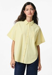 Lichtgele hemd met korte mouwen, voorzien van verticale strepen, een button-down kraag en een borstzakje. Zachte textuur en een relaxte pasvorm.