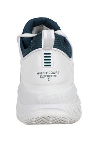 Bela atletska čevlja s oblazinjeno peto, teal barvnim ovratnikom, teksturiranim podplatom in logotipom "HYPERCOURT SUPREME 2" na zadnji strani.