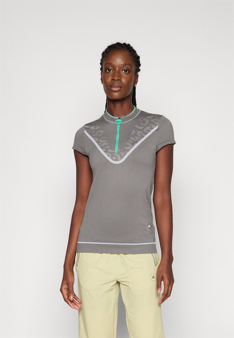 Gray short-sleeve polo shirt with a zip neck, featuring a subtle pattern and green accents. Soft material with contrasting trim details.