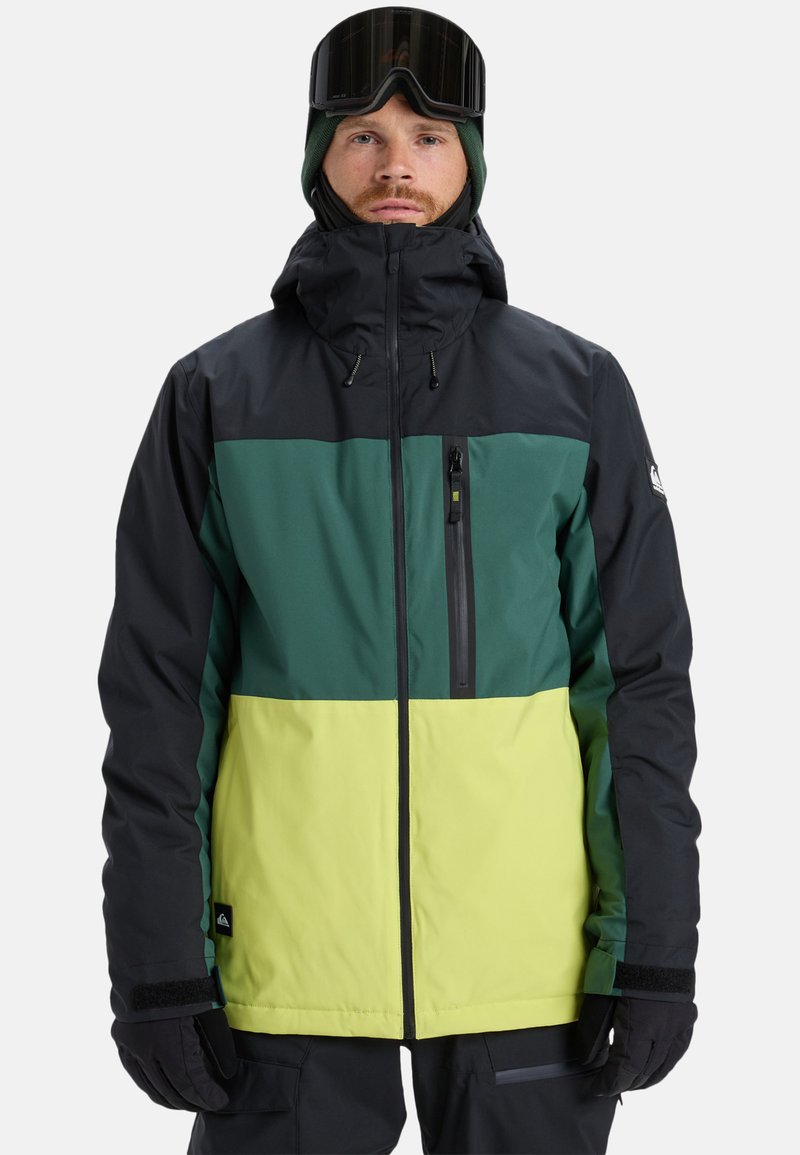 Ski jacket in black, green, and yellow color-block design. Features a high collar, adjustable hood, zippered chest pocket, and velcro cuffs.