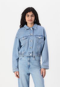Kort denimjacka i ljusblått, med knappframsida, bröstfickor och l�ång ärm med avslappnad passform och elastisk nederkant.