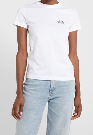 T-shirt en coton blanc avec un col rond et des manches courtes. Présente un petit motif graphique noir sur la poitrine. Coupe classique.