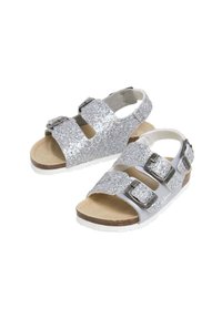 Hopeiset glitter-sandaalit, joissa on kaksisoljiset hihnat, kevyt muotoilu, beigenvärinen pohjallinen ja valkoinen ulkopohja. Avoin kantapää hengittävyyttä varten.