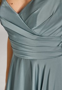 Satin-Kleid in schieferblau mit diagonalen Fälteln am Oberteil und fließendem Rock. Verfügt über einen V-Ausschnitt und eine glatte Textur.