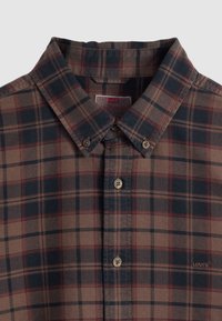 Καρό πουκάμισο σε καφέ κα ι ναυτικό μπλε με γιακά που κουμπώνει, με μπεζ κουμπιά και μικρό λογότυπο στο κάτω δεξιό μέρος.