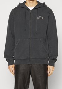 Felpa con zip grigia scura realizzata in misto cotone, con un logo frontale raffigurante un teschio e bandiere a scacchi, due tasche laterali e cappuccio con cordino.