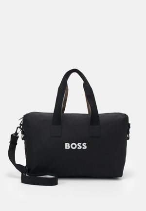 Črn najlonov potovalni kovček z kontrastnimi rjavimi ročaji in nastavljivim ramenskim trakom. Na sprednji strani se ponaša z izrazitim belim logotipom "BOSS".