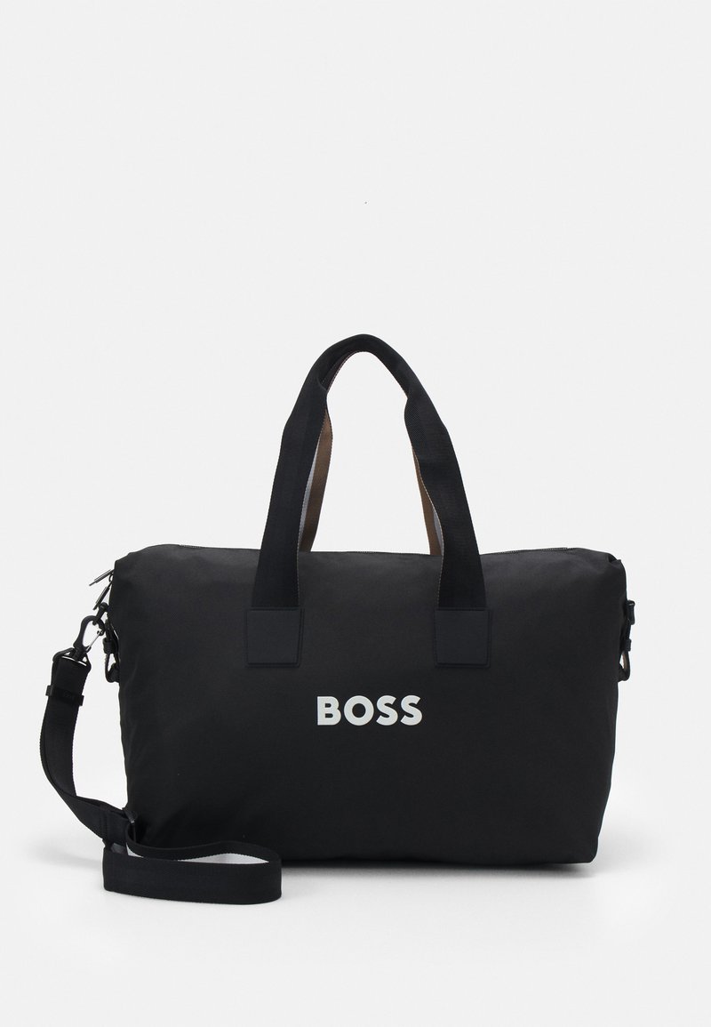 Geantă de voiaj din nylon negru cu mânere maro contrastante și curea de umăr reglabilă. Prezintă un logo alb proeminent „BOSS” pe față.