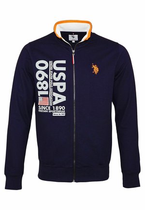 Mørkeblå lynlåstrøje med orange kant, hvid USPA 1890 tekst, det amerikanske flag og orange polospillerlogo på brystet.