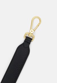 Cintura in pelle nera con una finitura testurizzata, dotata di una clip e di accessori in metallo dorato, che enfatizzano la durata e la funzionalità del design.