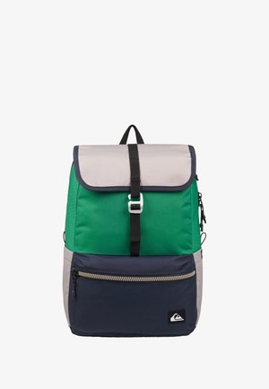 Rucksack mit hellgraßer oberer Klappe, grünem Mittelteil und marineblauer, mit Reißverschluss versehener Fronttasche, ausgestattet mit einem schwarzen Riemen und Griff vor weißem Hintergrund.