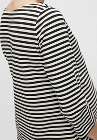 Mustavalkoinen raidallinen yläosa, jossa on venetsialainen kaula-aukko ja kolme neljäsosaa hihat, valmistettu pehmeästä ja joustavasta kankaasta.