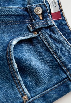 Jeans din denim într-o nuanță deep blue cu un margine de buzunar uzat. Buton metalic și detalii de cusătură contrastantă vizibile aproape de talie.