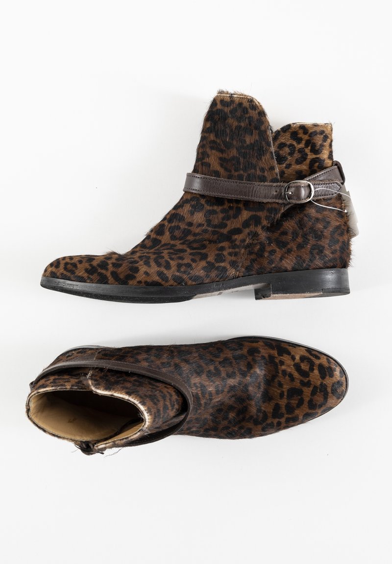 Bottes cheville en fourrure imprimé léopard avec bout rond, bride en cuir marron et détail boucle, semelle plate en caoutchouc noir.