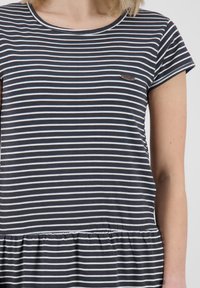 Raidallinen, lyhythihainen paita tummanharmaana ja valkoisena, jossa on kerätty vyötärö ja pieni logopatch rintataskussa. Pehmeää puuvillamateriaalia.