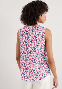 Top senza maniche floreale con base bianca e motivi floreali rosa, blu e verdi. Tessuto morbido con un fit rilassato e orlo arrotondato.