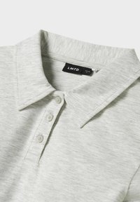 Lichtgrijs overhemd met kraag, drie beige knopen en een zwart label binnenin de nek, gemarkeerd "LMTD" maat 13-14 S.