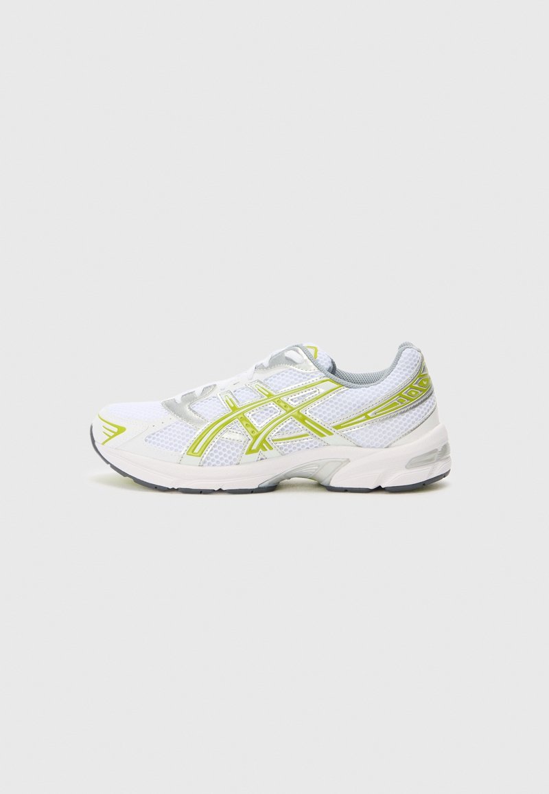 Chaussure de course blanche et grise avec des accents jaune néon et un tissu en maille, vue du côté extérieur sur un fond uni.