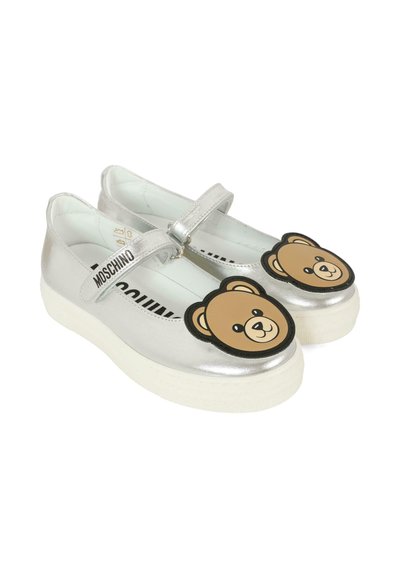Scarpe Mary Jane argento con un design a faccia d'orso sulla punta, una cinghia sopra il piede e una suola in gomma bianca. Texture liscia.