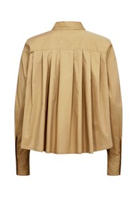 Chemise beige à manches longues avec des plis dans le dos et un col classique, présentée sur fond blanc.