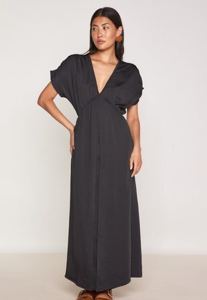 Robe longue noire avec un décolleté en V profond, manches courtes bouffantes et taille élastique. Fabriquée dans un tissu doux et lisse avec une silhouette fluide.