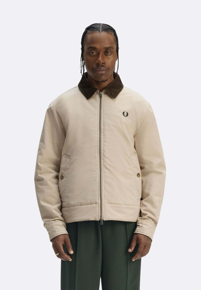 Giacca bomber beige con colletto in velluto a coste, zip frontale, tasche laterali e logo ricamato sul petto. Tessuto dalla trama liscia.