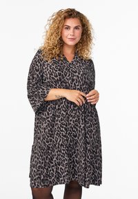 Robe à imprimé léopard avec un décolleté en V, des manches trois-quarts et un design de jupe à volants. Tissu doux avec une silhouette fluide.