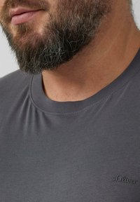 Szary t-shirt z krótkim rękawem wykonany z gładkiej tkaniny, z okrągłym dekoltem i małym haftowanym logo "s.Oliver" na lewej piersi.
