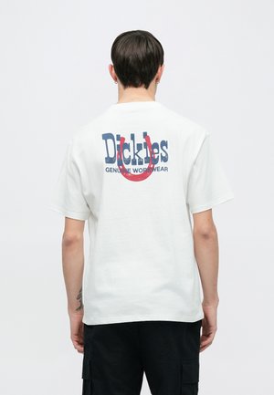 Hvit bomulls-T-skjorte med et stort marineblått og rødt grafisk trykk på ryggen med teksten «Dickies Genuine Workwear». Kortermet, avslappet passform.