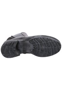 Black leather boot with a textured rubber sole, featuring deep tread patterns and visible stitching along the upper for added durability.
