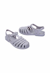 Sandali in plastica lilla chiaro con design a fascia intrecciata, cinturino alla caviglia regolabile, suola piatta e punta aperta per una migliore traspirabilità.