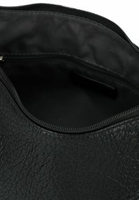 Schwarze, strukturierte Ledertasche mit einem Reißverschluss oben, ausgestattet mit einem glatten Innenfutter und einer kleinen Innentasche.