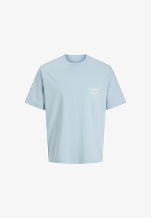 Heled sinine puuvillane T-särk ümarate kaelustega, lühikeste varrukatega ja valge trükitud tekstiga vasakul rinnal, millel on sile tekstuur.