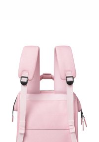 Rosa Rucksack mit gepolsterten Schulterriemen, einem oberen Griff, verstellbaren Seitenschnallen und einer glatten Textur. Reißverschlussanhänger und Akzentnähte sichtbar.