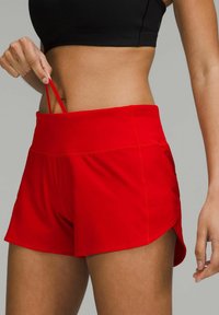 Pantalones cortos deportivos rojos con una cinturilla ancha, que presentan un diseño fruncido y bolsillos laterales. Fabricados en un tejido ligero y suave.
