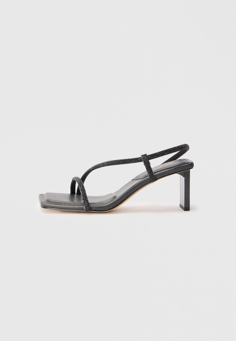 Sandalo nero con strappi e punta quadrata, dotato di tacco a blocco. Presenta sottili cinturini metallici e una suola in pelle liscia. Design minimalista.