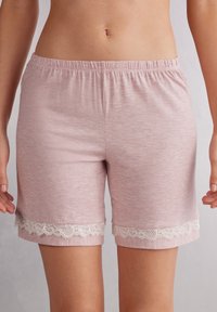 Lichtroze katoenen shorts met een elastische tailleband, voorzien van witte kantafwerking aan de zoom. Zachte textuur met een casual ontwerp.