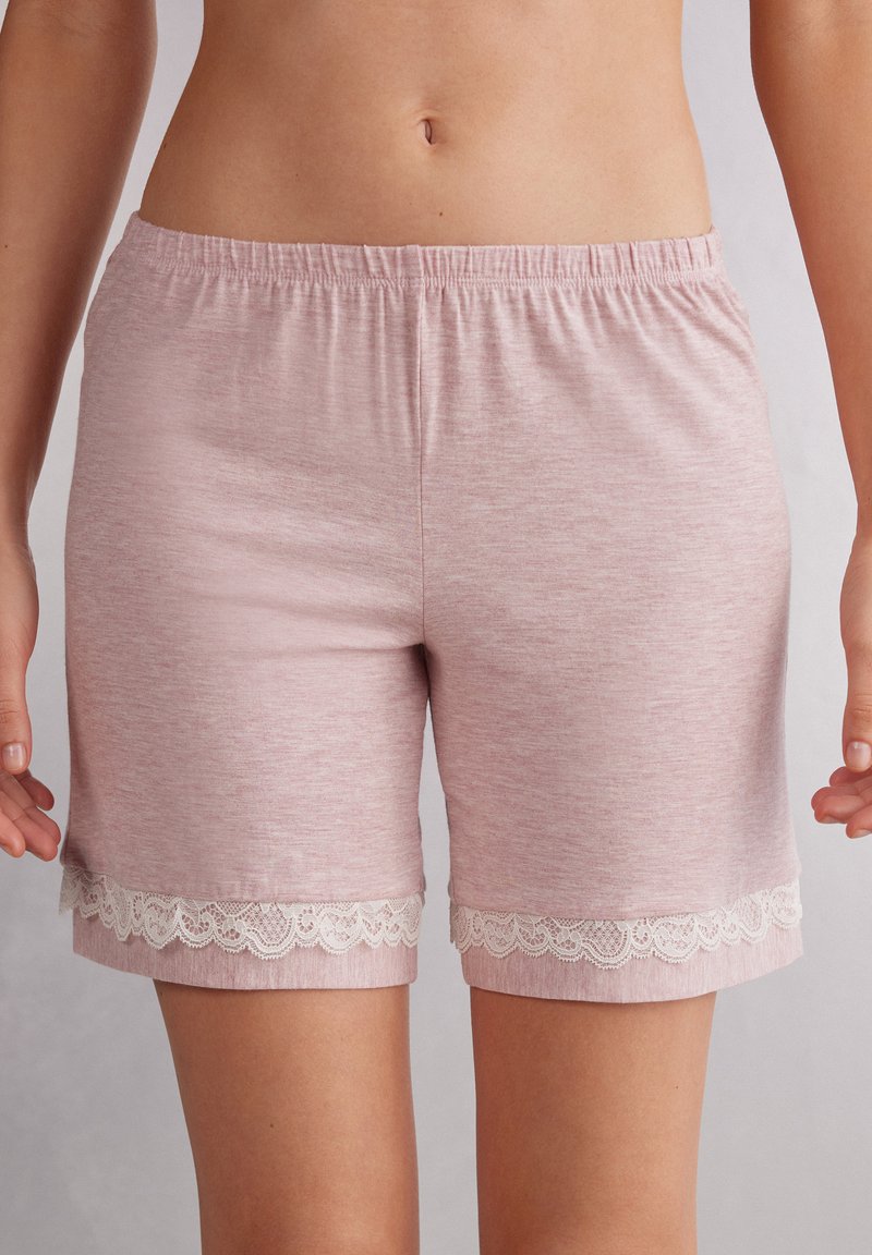 Lichtroze katoenen shorts met een elastische tailleband, voorzien van witte kantafwerking aan de zoom. Zachte textuur met een casual ontwerp.
