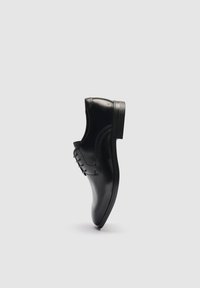 Chaussure de ville en cuir noir poli avec lacets, vue de profil sur un fond clair uni.