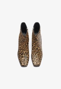 Bottines en cuir texturé à imprimé léopard, avec un bout pointu et des zips sur le côté, dotées d'une finition noire élégante.