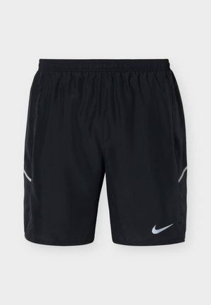 Short de sport noir avec taille élastique, bandes latérales réfléchissantes et un petit logo Nike blanc sur la partie inférieure de la jambe droite.