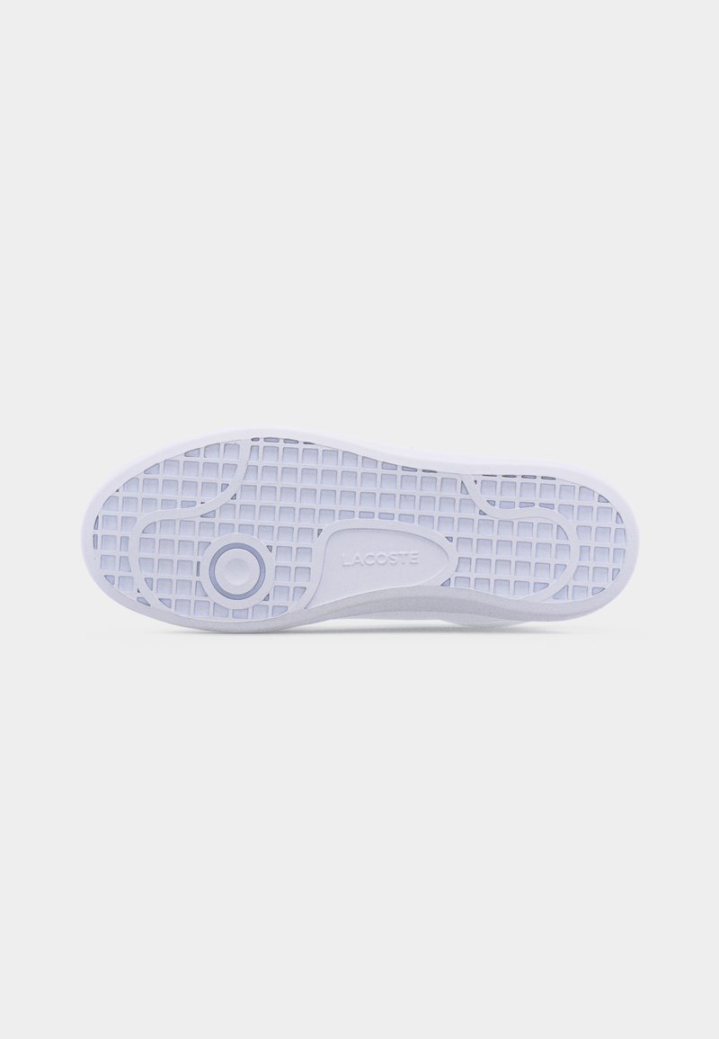 Sole of a white Lacoste sneaker with grid tread pattern and circular grip detail on a plain light background.