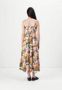 Blommig maxikjol med justerbara spaghettistraps, lagerdesign, flerfärgade blommor på en ljus bakgrund, lättviktsmaterial, matchat med svarta skor.