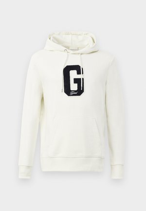 Kremna kapuca iz bombaža, ki vsebuje sprednji kenguru žep, vrvici in črno vezeno 'G' logotip.