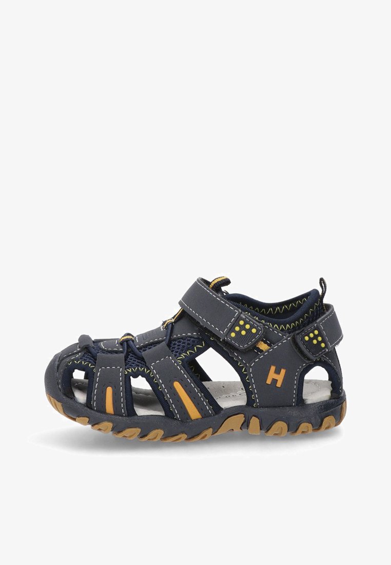 Sandalia azul con acentos naranjas, hecha de material sintético, presenta un diseño de punta abierta, tiras de Velcro y una suela texturizada con un agarre estampado.