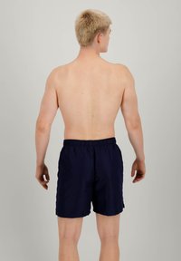 Pantaloni da nuoto blu navy con cintura elastica, taglio a lunghezza media e un tessuto liscio e leggero. Senza motivi o decorazioni visibili.