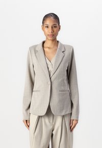 Helles graues Fischgrät-Blazer mit Revers, einzelner Knopfverschluss und zwei Vordertaschen, getragen über einem passenden knöpfbaren Oberteil.